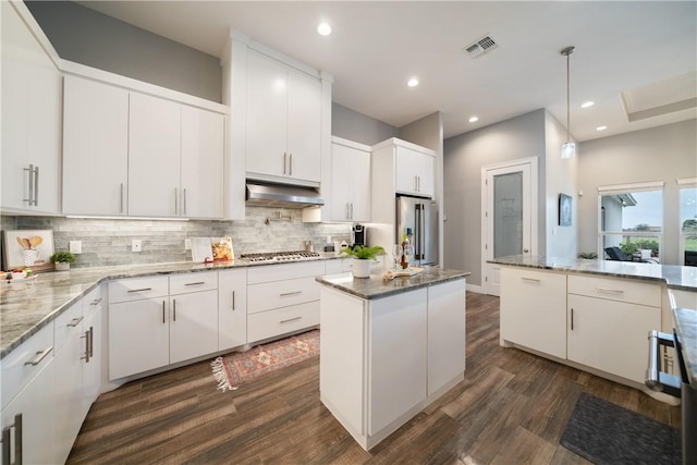 kitchen featuring white cabinets, a kitchen island, appliances with stainless steel finishes, and pendant lighting