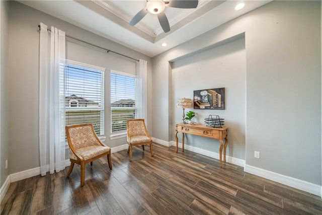 sitting room featuring dark hardwood / wood-style flooring, a raised ceiling, ceiling fan, and crown molding