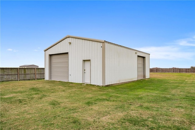 view of outbuilding featuring a lawn and a garage