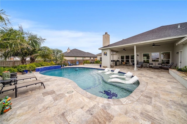 view of swimming pool featuring pool water feature, ceiling fan, and a patio area