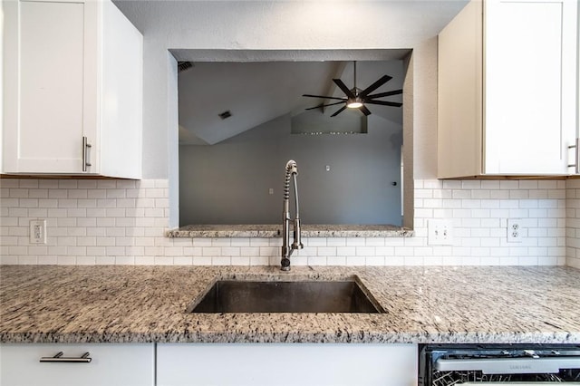 kitchen featuring a ceiling fan, decorative backsplash, lofted ceiling, dishwashing machine, and a sink