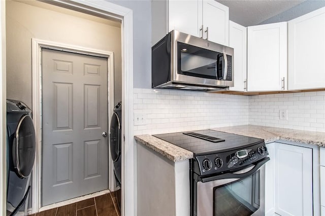 kitchen featuring washer / clothes dryer, appliances with stainless steel finishes, white cabinets, and dark wood-style floors