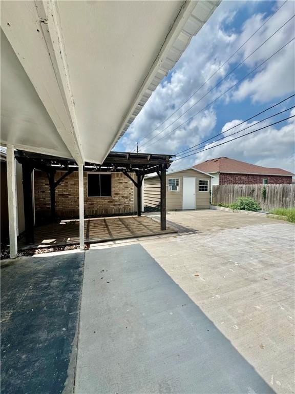 view of patio with fence, an outdoor structure, and a shed