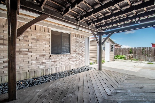 wooden terrace with a patio area and fence