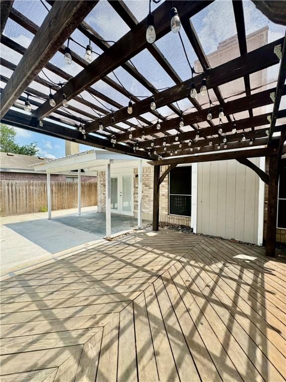 wooden terrace featuring a pergola, fence, and french doors