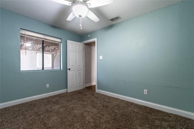 spare room with visible vents, carpet flooring, baseboards, and ceiling fan