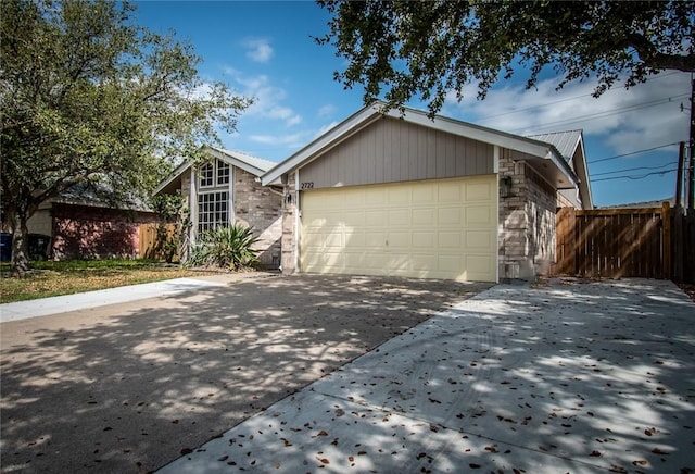 view of front of house featuring fence, an attached garage, and driveway