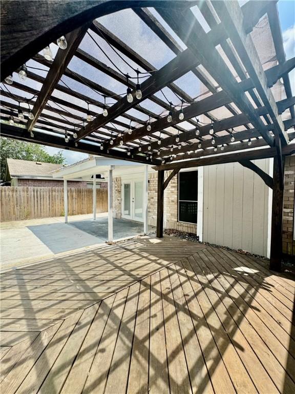 wooden terrace featuring french doors, fence, and a pergola