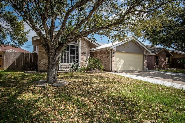 view of front of home with driveway, brick siding, fence, a front lawn, and an attached garage