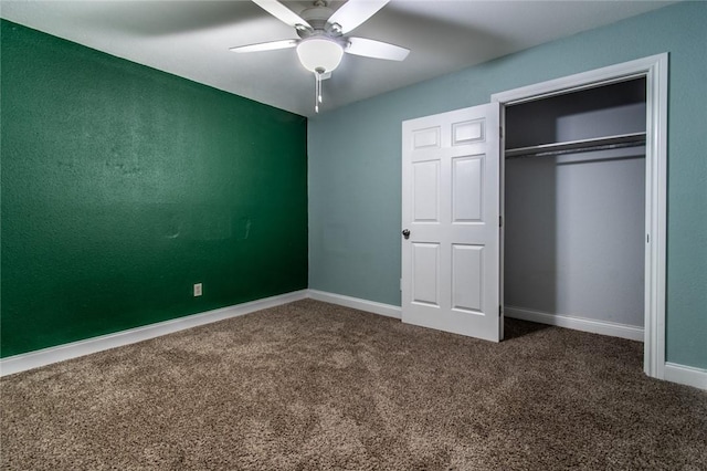 unfurnished bedroom featuring dark carpet, baseboards, ceiling fan, and a closet