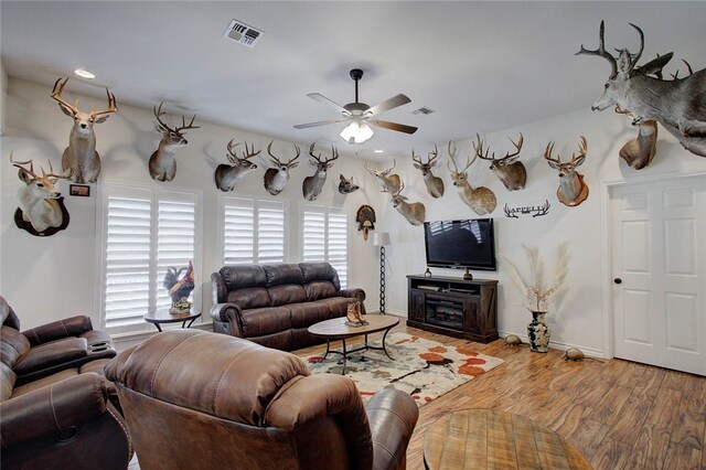 living room with ceiling fan, a wealth of natural light, and wood-type flooring