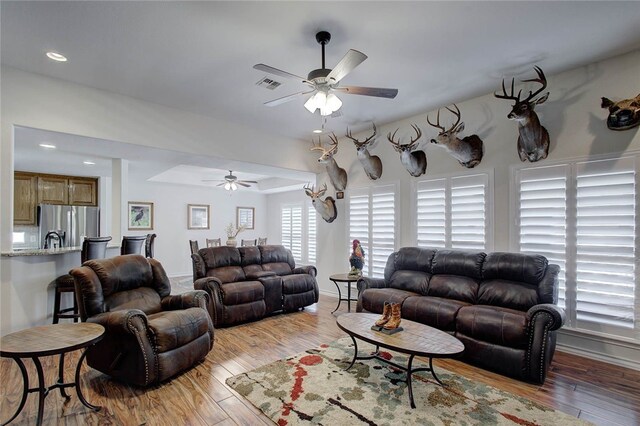 living room featuring ceiling fan and light hardwood / wood-style flooring