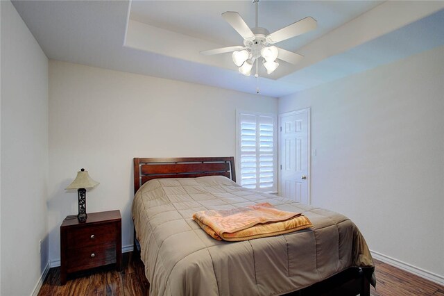 bedroom with dark hardwood / wood-style flooring and ceiling fan