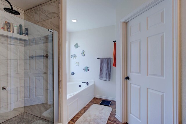 bathroom featuring plus walk in shower and hardwood / wood-style flooring