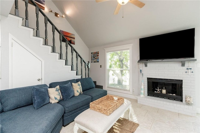 living area with a ceiling fan, stairway, a fireplace, tile patterned flooring, and lofted ceiling