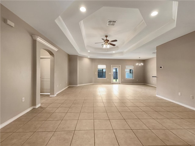 tiled spare room featuring ceiling fan with notable chandelier, crown molding, and a tray ceiling