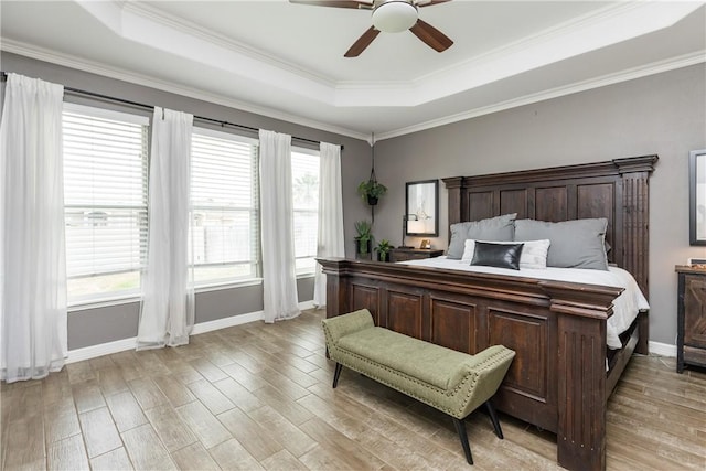 bedroom with crown molding, ceiling fan, a raised ceiling, and light hardwood / wood-style floors