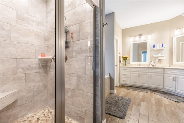 bathroom with hardwood / wood-style flooring, vanity, and an enclosed shower