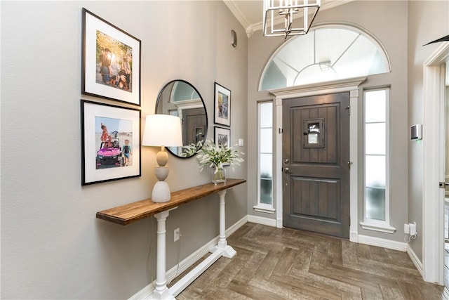 foyer entrance with dark parquet flooring, a towering ceiling, and crown molding