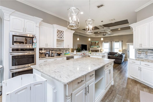 kitchen with white cabinetry, decorative light fixtures, coffered ceiling, and appliances with stainless steel finishes