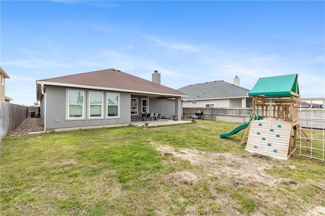 back of house with a lawn, a playground, and a patio area