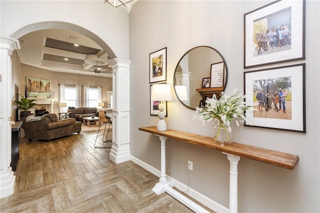 hallway featuring decorative columns, coffered ceiling, and light parquet floors