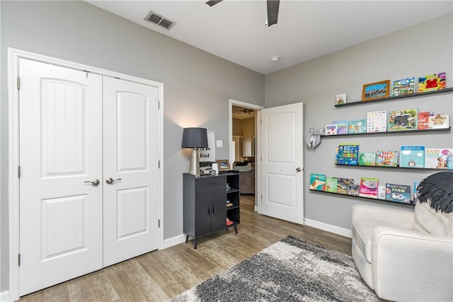 sitting room with hardwood / wood-style floors and ceiling fan