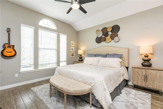 bedroom with multiple windows, hardwood / wood-style flooring, vaulted ceiling, and ceiling fan