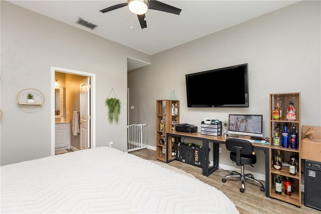 bedroom with connected bathroom and light hardwood / wood-style floors