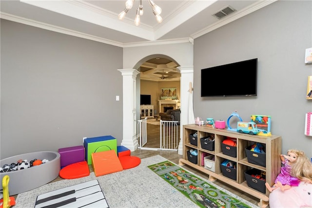 recreation room with a raised ceiling, crown molding, and ceiling fan with notable chandelier