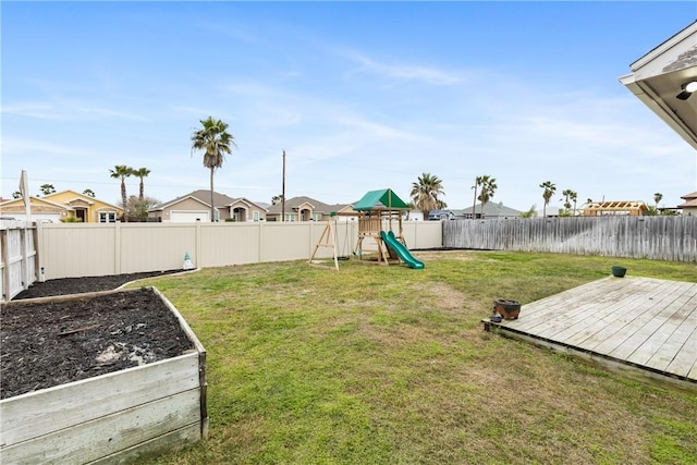 view of yard with a wooden deck and a playground