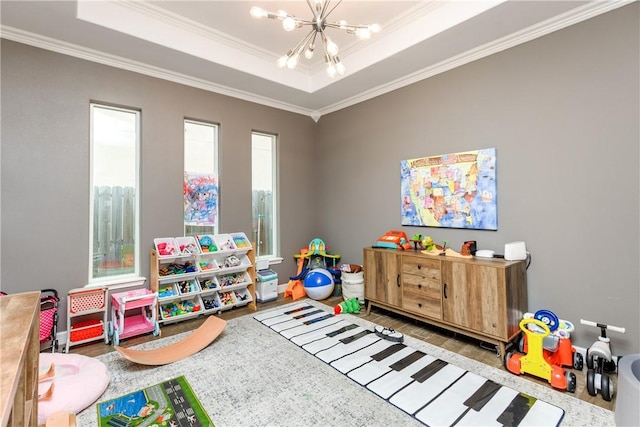 game room featuring a notable chandelier, hardwood / wood-style flooring, ornamental molding, and a raised ceiling