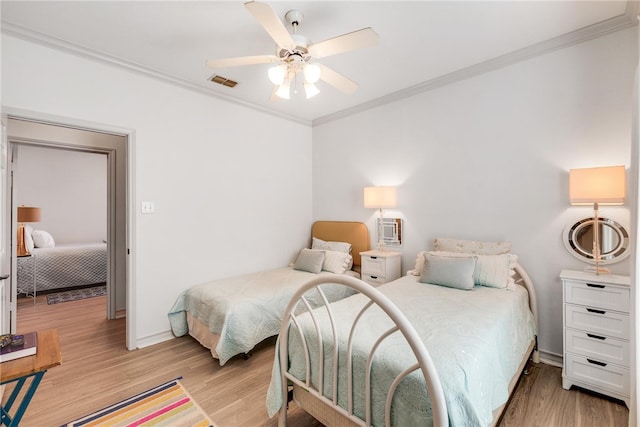 bedroom featuring crown molding, ceiling fan, and light hardwood / wood-style flooring