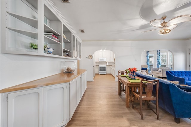 interior space with light hardwood / wood-style floors, ceiling fan, and crown molding