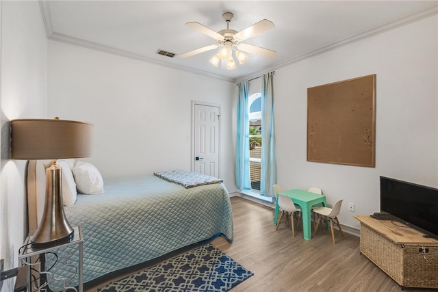 bedroom with hardwood / wood-style flooring, ceiling fan, and crown molding