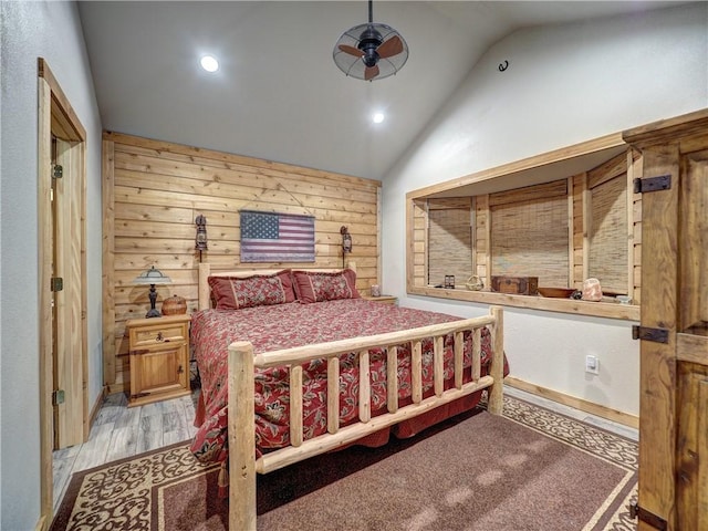 bedroom with light wood finished floors, wooden walls, vaulted ceiling, and recessed lighting