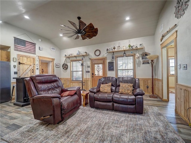 living room with lofted ceiling, a wainscoted wall, plenty of natural light, and wood finished floors