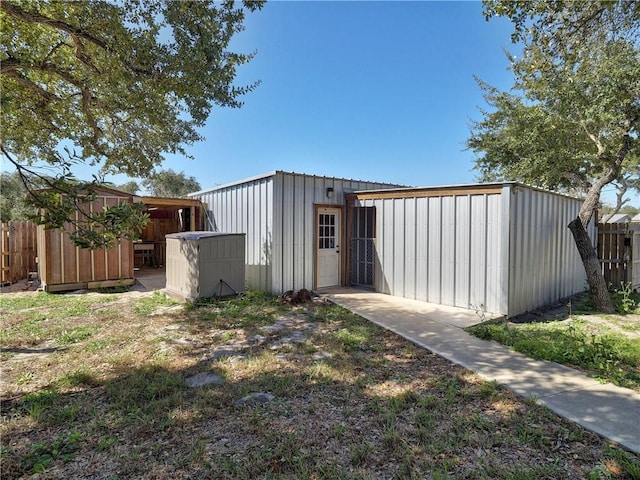 view of outdoor structure featuring fence and an outdoor structure