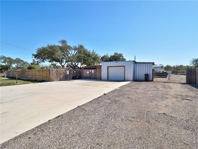 garage with fence and concrete driveway