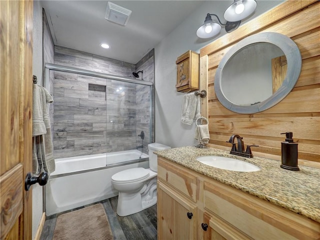 full bathroom featuring enclosed tub / shower combo, vanity, toilet, and wood finished floors