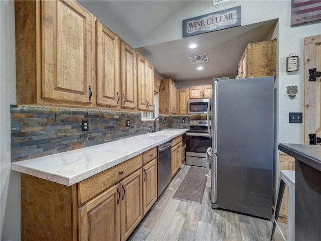 kitchen featuring light countertops, visible vents, backsplash, appliances with stainless steel finishes, and a sink