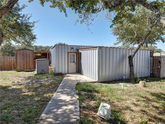 view of outbuilding with fence and an outdoor structure