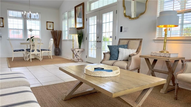 interior space featuring light tile patterned floors, a chandelier, lofted ceiling, baseboards, and french doors