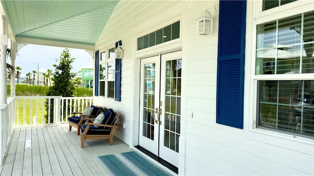 wooden terrace featuring a porch and french doors