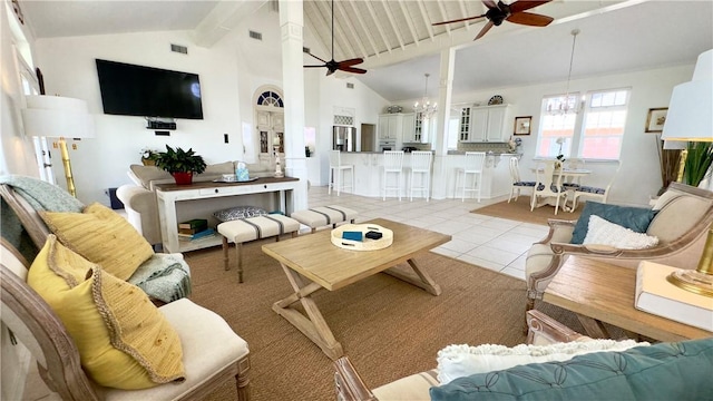 living area featuring ceiling fan with notable chandelier, high vaulted ceiling, light tile patterned flooring, and visible vents