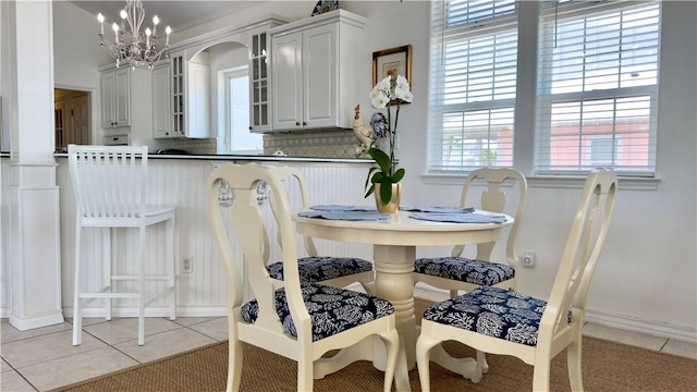 dining area featuring light tile patterned flooring and a notable chandelier