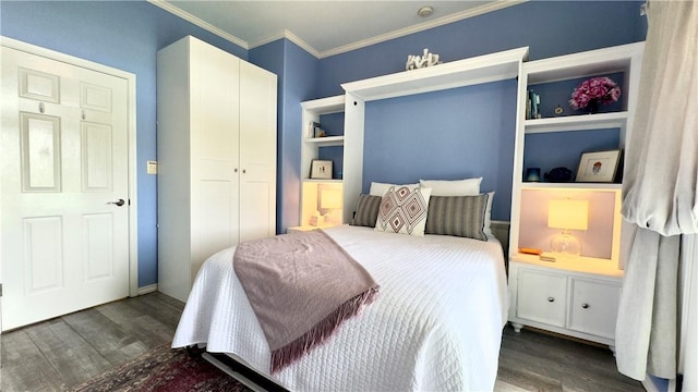 bedroom with dark wood-style floors, ornamental molding, and a closet