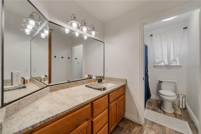 bathroom with vanity, toilet, and hardwood / wood-style flooring