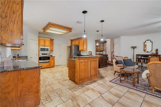 kitchen featuring pendant lighting, appliances with stainless steel finishes, dark stone countertops, sink, and kitchen peninsula