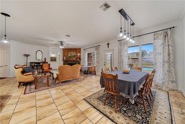 tiled dining room featuring ceiling fan and ornamental molding